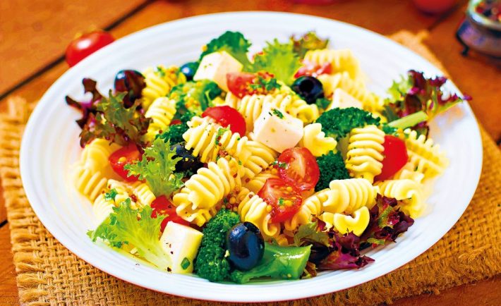 Pasta salad with tomato, broccoli, black olives,  and cheese feta